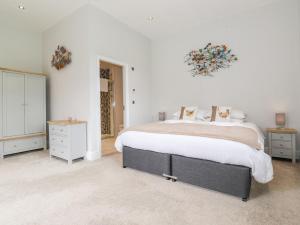 1 dormitorio con 1 cama grande y paredes blancas en The Gatehouse en Kendal