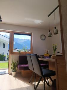 a dining room with a table and chairs and a window at Alpenoase in Schwendau