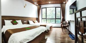 um quarto de hotel com duas camas e uma janela em Rosalia Tam Đảo Hotel em Tam Dao