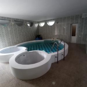 a bathroom with two tubs and a swimming pool at Private Luxury Villa - Issyk Kul in Cholpon-Ata