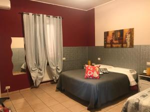 a bedroom with two beds and a red wall at Vegan Inn Airport - Adults Only in Fiumicino