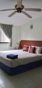 a bedroom with a large bed with a ceiling fan at Kingfisher House and Bar in Pattaya South