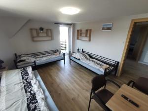 3 łóżka w pokoju z drewnianą podłogą w obiekcie Tanie Noclegi, kwatery, pokoje do wynajęcia , TARGI KIELCE w Kielcach