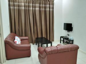 a living room with two leather chairs and a television at PINTARMAN EXPRESS @ MIRI TIMES SQUARE in Miri