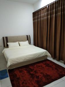 a bedroom with a bed and a red rug at PINTARMAN EXPRESS @ MIRI TIMES SQUARE in Miri