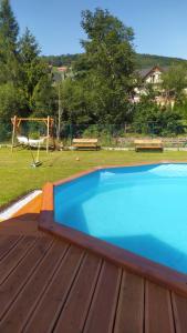 una piscina azul en una terraza con parque infantil en Czesławka, en Zawoja