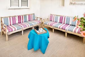 a room with two couches and a table with a side table at siciliacasevancaze - Villa Torre in Punta Secca