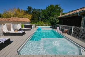 una piscina con terraza y un patio en Le Cocon, en Saint-Paul-les-Fonts