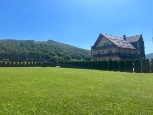 Pensiunea Miorița Putna في بوتنا: منزل كبير في حقل من العشب +34 صورة