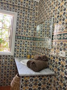 uma casa de banho com um lavatório, uma janela e toalhas em Maison d'Hote Domaine El-Manar em Zarzis