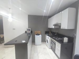 een keuken met witte kasten en een zwart aanrecht bij roof top duplex with solarium in Bouznika