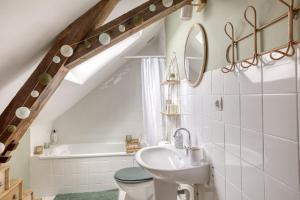 y baño con lavabo, aseo y bañera. en Gîte L'Escale - Maison de charme, en Chambellay