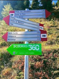 ボルミオにあるCASA CARCENTINAの色々な看板が貼られた道路標識