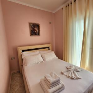 1 dormitorio con 1 cama con toallas en Amelia Apartments en Ksamil
