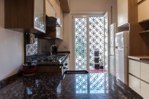 eine Küche mit einem Herd, einer Spüle und einem Kühlschrank in der Unterkunft Spazioso appartamento vicino EUR in Rom