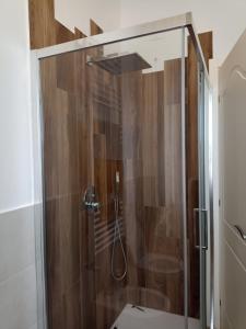 W łazience znajduje się prysznic ze szklanymi drzwiami. w obiekcie L'Orizzonte w mieście Castelfidardo