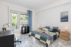 a white bedroom with a bed and a desk and a desk at Spazioso appartamento vicino EUR in Rome