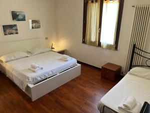 een slaapkamer met 2 bedden en een raam bij Sosta Paradisa in Pisa
