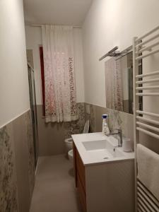 a bathroom with a sink and a toilet and a mirror at L'Orizzonte in Castelfidardo