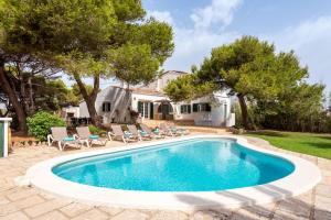 - une piscine avec des chaises et une maison dans l'établissement Hort d'es Milord - Es Castell, à Es Castell