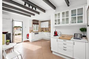 - une cuisine avec des armoires et des appareils blancs dans l'établissement Hort d'es Milord - Es Castell, à Es Castell