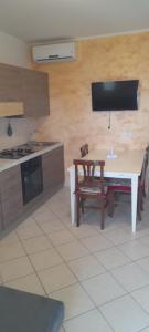 una cucina con tavolo, TV, tavolo e sedie di Casa vacanza Giorgiani a Torre Pali