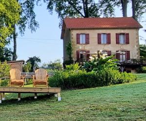 dos sillas y una mesa frente a una casa en Chambre d'hôte, en Castex