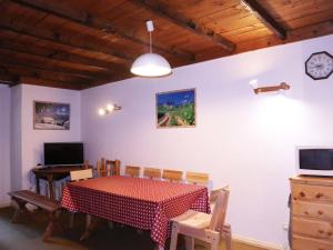 a dining room with a table and chairs and a clock at Appartement Les Orres, 2 pièces, 6 personnes - FR-1-322-218 in Les Orres