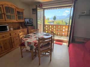 a kitchen with a table and chairs with a view at Appartement Praz-sur-Arly, 2 pièces, 4 personnes - FR-1-603-39 in Praz-sur-Arly