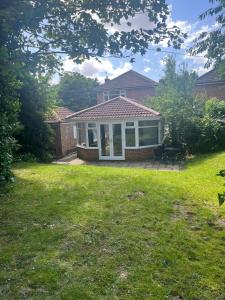 a house with a screened in porch and a yard at The Village apartment. in Marton