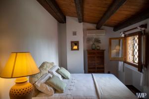 1 dormitorio con 1 cama con lámpara y ventana en Villa Audino, en Scopello