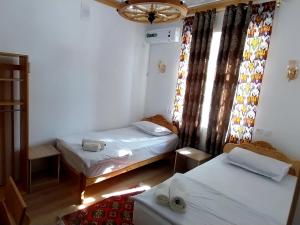 ein kleines Zimmer mit 2 Betten und einem Fenster in der Unterkunft NAZIRA Boutique Hotel in Xiva