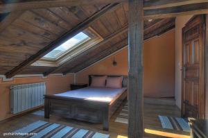 a bedroom with a large bed with a skylight at Gozbarov's Guest House in Koprivshtitsa