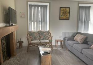 - un salon avec un canapé et une télévision dans l'établissement Kilaturley house apartment, à Swinford