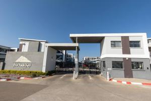 a large white building with a gate in front of it at One More Night Apartment E203 in Gaborone