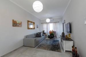 a living room with a couch and a table at One More Night Apartment E203 in Gaborone +1 photo