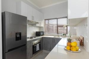 a kitchen with a bowl of fruit on the counter at One More Night Apartment E203 in Gaborone