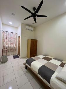 a bedroom with a bed and a ceiling fan at Magnolia homestay 2 