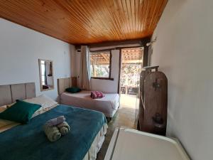 um quarto com 2 camas num quarto com uma janela em Pousada Flor de Maio - Vila De São Jorge em Alto Paraíso de Goiás