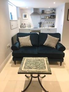 a living room with a blue couch and a table at Studio at Church House in Bideford