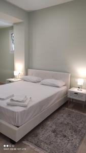 een slaapkamer met een groot wit bed en 2 tafels bij Diacopto Country Houses in Diakopto