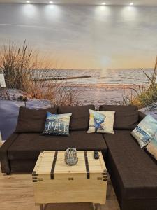a brown couch sitting in front of a beach at Wellenrauschen - Whirlpool Badewanne - Terrasse - Ruhig gelegen in Wilhelmshaven
