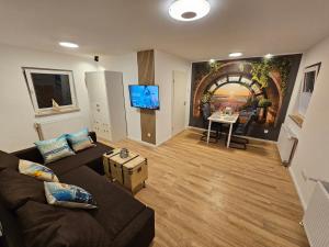 a living room with a couch and a table at Wellenrauschen - Whirlpool Badewanne - Terrasse - Ruhig gelegen in Wilhelmshaven