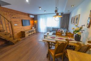 a living room with a table and a couch at Śnieżna Łapa in Zakopane