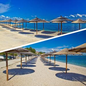a row of straw umbrellas on a beach at Apartma Šmit in Vir