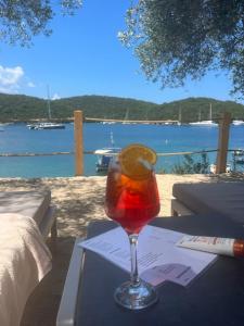a drink in a glass on a table with a view of the water at Sivota Deamaris Luxury Boutique Hotel in Syvota