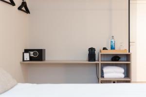 Dormitorio con cama y estante con radio en Makkan Club, en Oleiros