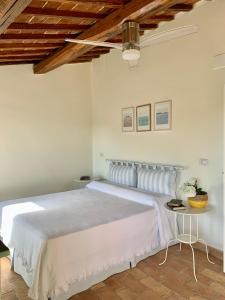a bedroom with a large white bed with a wooden ceiling at Civita Secret Lodge in Lubriano
