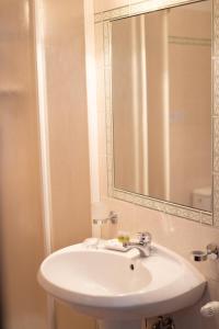 bagno con lavandino bianco e specchio di Hotel Napoleon a Pontremoli