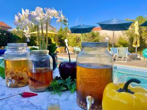 uma mesa com três frascos de bebidas ao lado de uma piscina em Le Galion Hotel et Restaurant Canet Plage - Logis em Canet-en-Roussillon